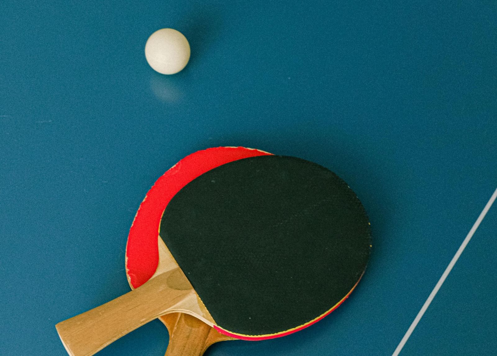 Two table tennis paddles and a ball on the table