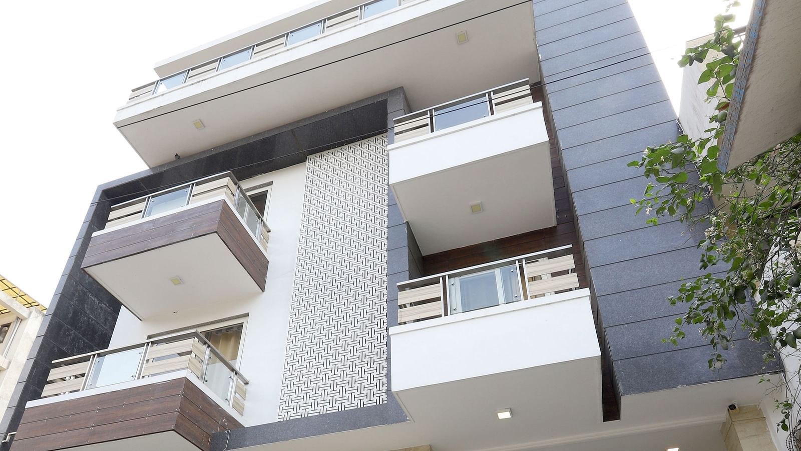 A contemporary building with a unique stacked design and balconies is viewed from a low angle - Asian Suites Cyber Park, Gurgaon