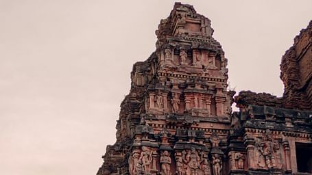 Ancient temple tower with ornate carvings against a dusky sky.