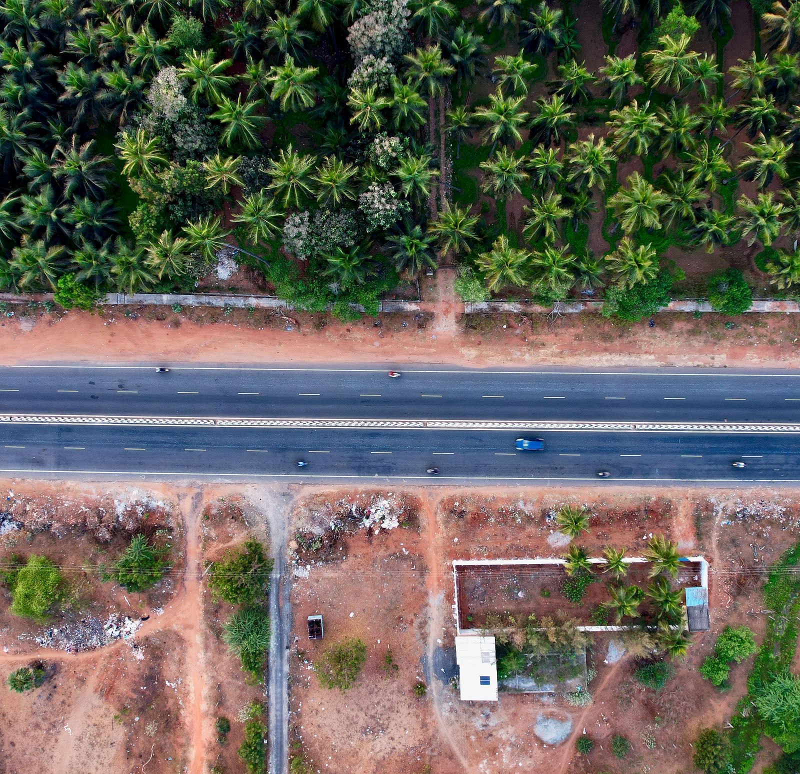 Aerial view of a road passing through a forest.