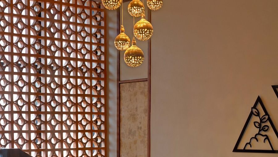 Image of a chandelier hanging from a lit up ceiling at Coral Reef Hotel and Spa in Port Blair