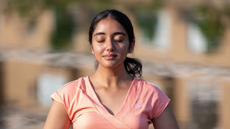 A woman dressed in yoga attire performing a yoga asan on a purple coloured yoga mat - Rajbagh Wellness, Udaipur 
