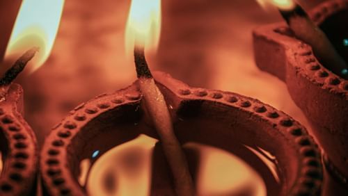 Close-up of three oil lamps lit and placed together.