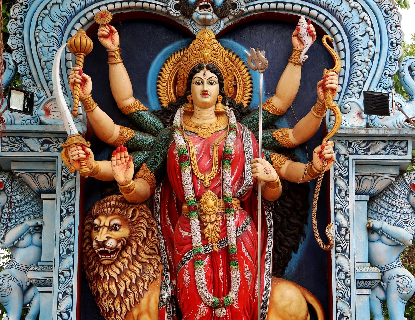 a statue of goddess Durga with a lion behind her