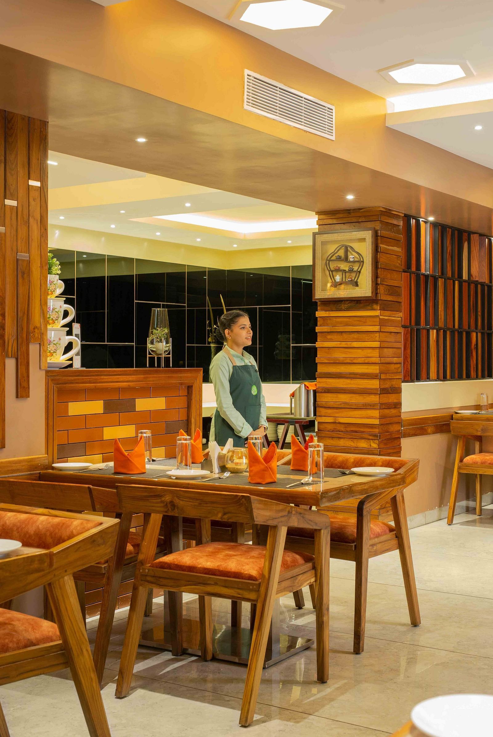 A waitress in uniform standing in a cafe.