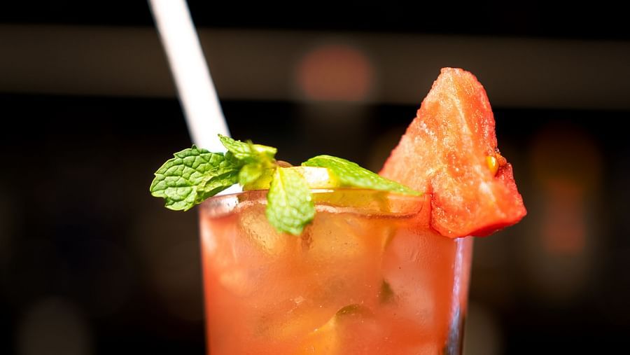 A close-up of a strawberry cocktail garnished with mint on a bed of crushed ice - TGI Ameya Grand, Goa