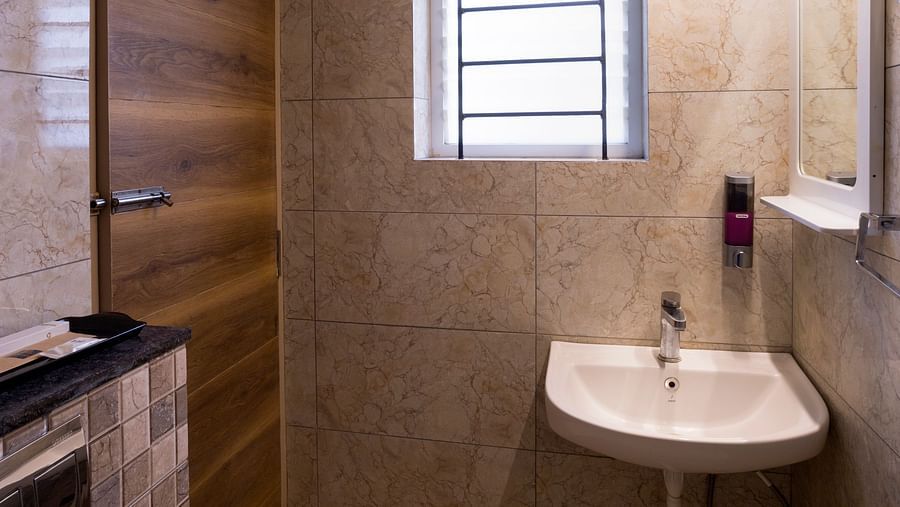 Modern bathroom with sink and wall mirror – Nirantara Resort & Spa