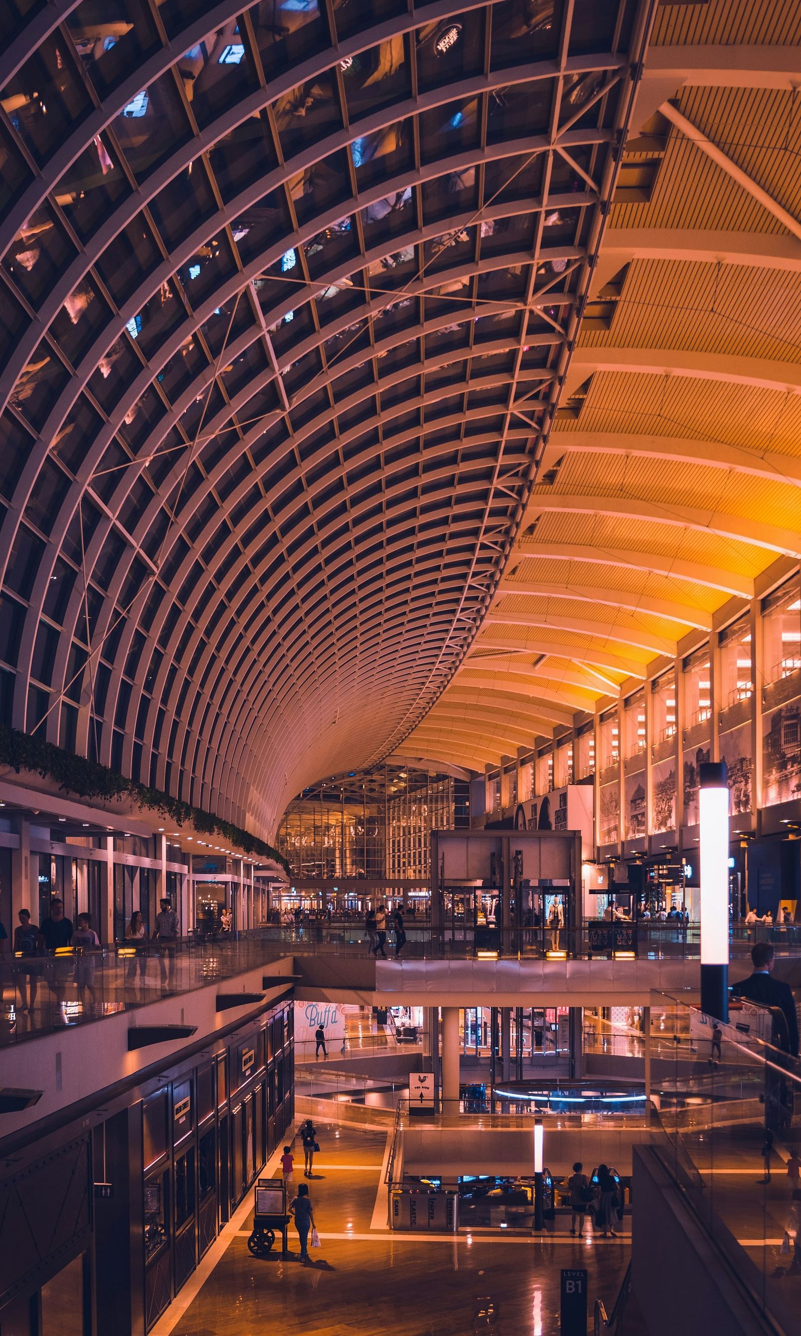  A warming light bathes the mall area, casting a soft, inviting glow that enhances the rich tones of the polished floors and stylish displays