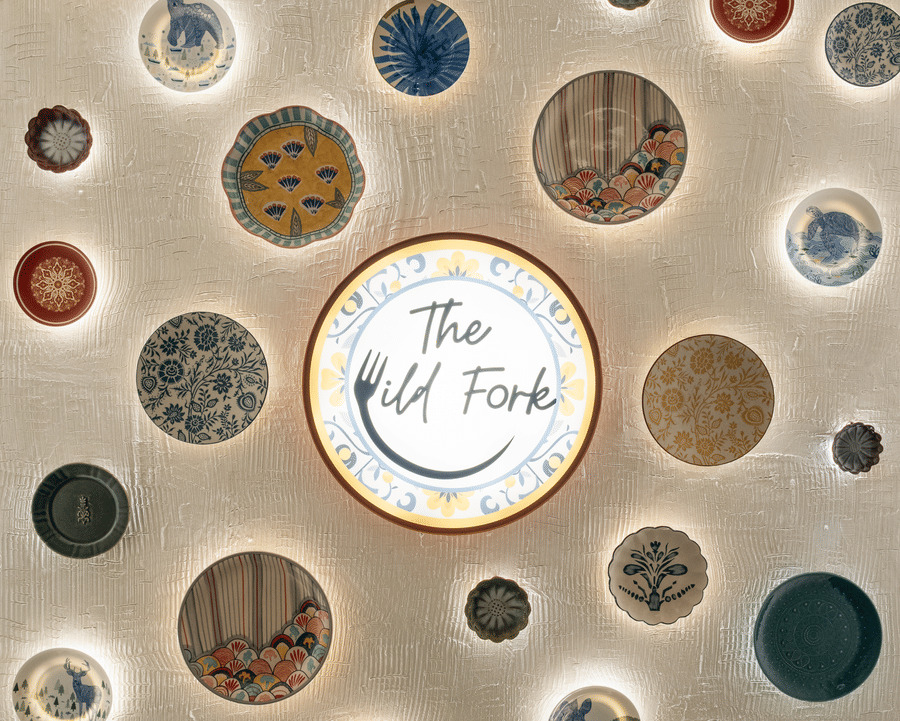 Logo of The Wild Fork restaurant along with several other artworks placed on the wall at La Marvella, Bengaluru