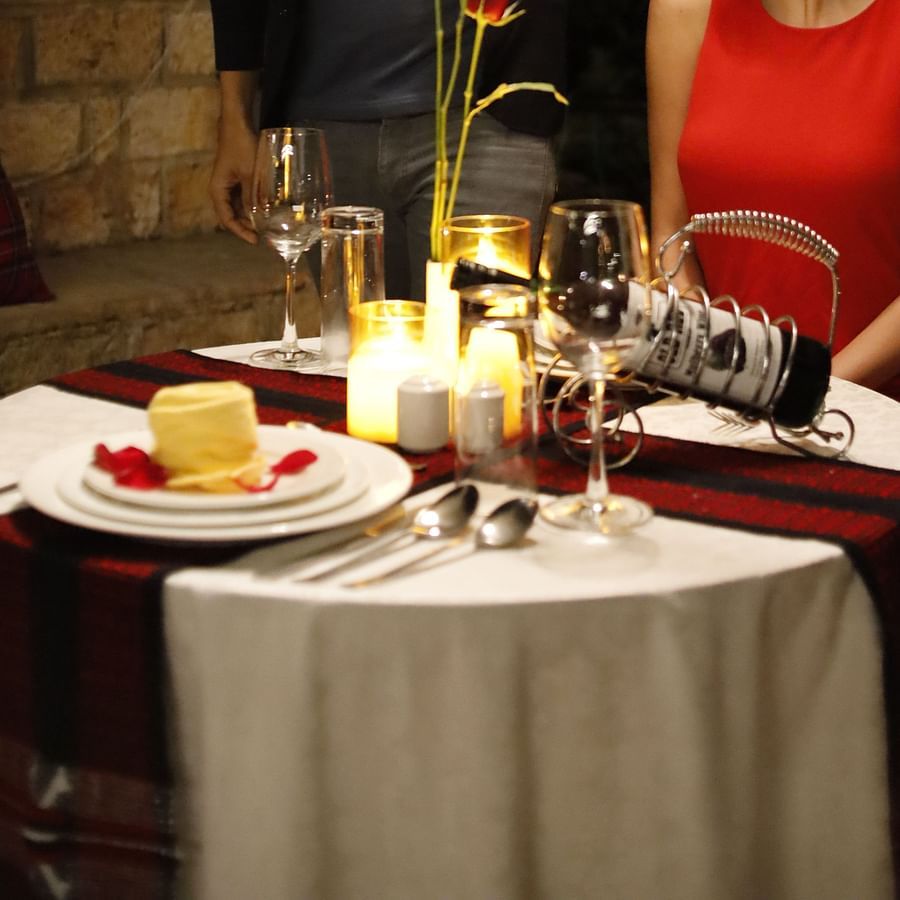 An image of a man staring at a woman on a candle light dinner table -Polo Orchid Resort, Cherrapunji