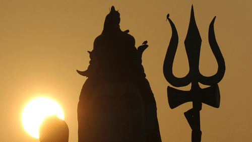 Idol of Lord Shiva facing the sun. Image taken from behind giving silhouette effect.