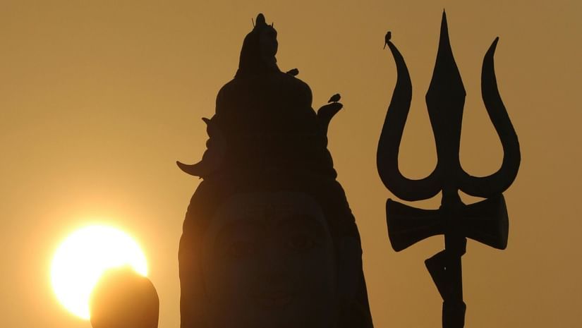 Idol of Lord Shiva facing the sun. Image taken from behind giving silhouette effect.