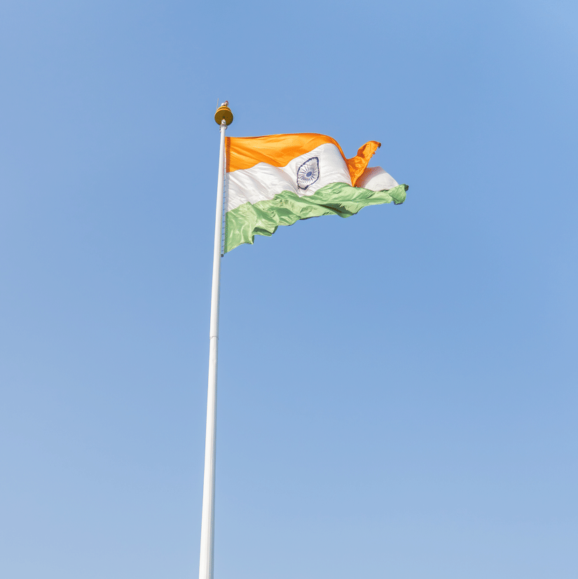 A group of people standing in front of the Indian flag - Karma Lakelands.