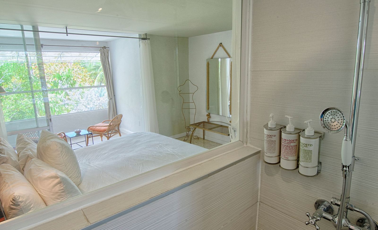 Shower area at Casa Morada with glass panel and wall-mounted fixtures beside a tub.