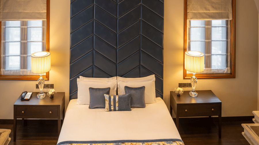 Presidential Suite bedroom with a bed set within an arched alcove at Kenilworth Hotel, Kolkata.