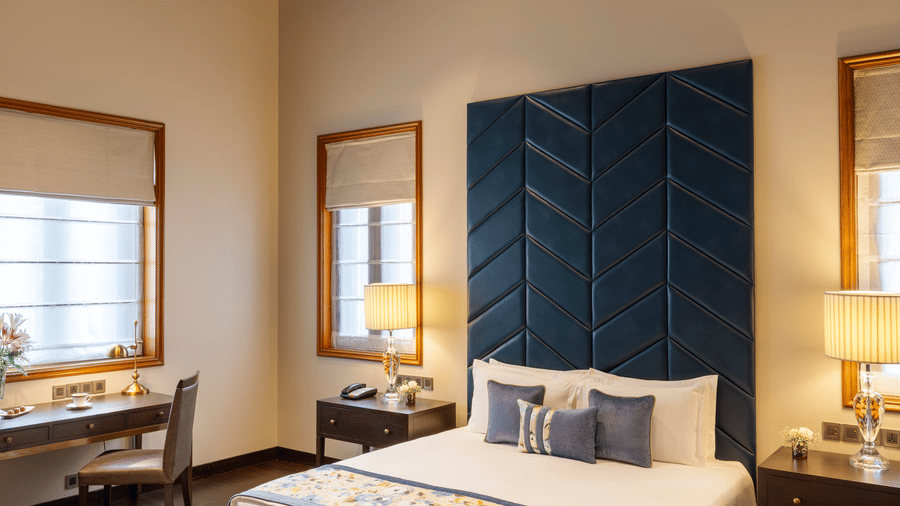 Presidential Suite bedroom with a bed and a striking patterned ceiling design at Kenilworth Hotel, Kolkata.