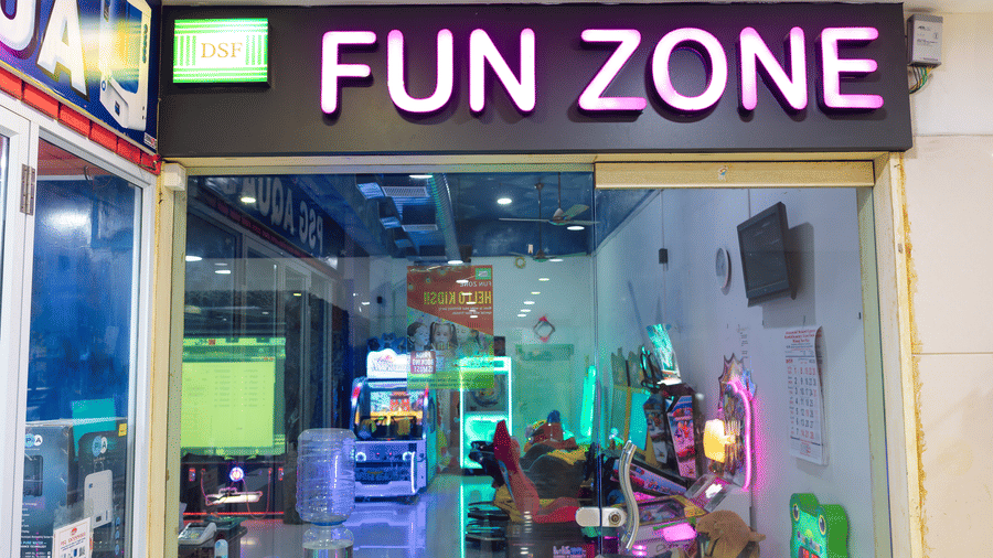 DSF Fun Zone storefront entrance at DSF Grand Plaza, Tuticorin with an illuminated pink neon sign, glass sliding doors, and arcade games visible inside.