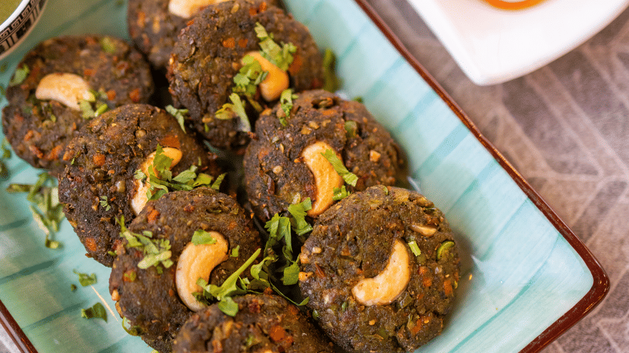 View of cutlets or kebabs on a blue plate with garnishing and side dishes at Pravasa Stay Luv Kush, Indore.