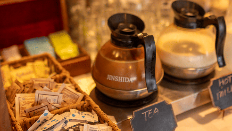A shelf with jars, cups, and packaged items arranged on a wooden surface at Indraprastha Resort & Spa, McLeod Ganj.