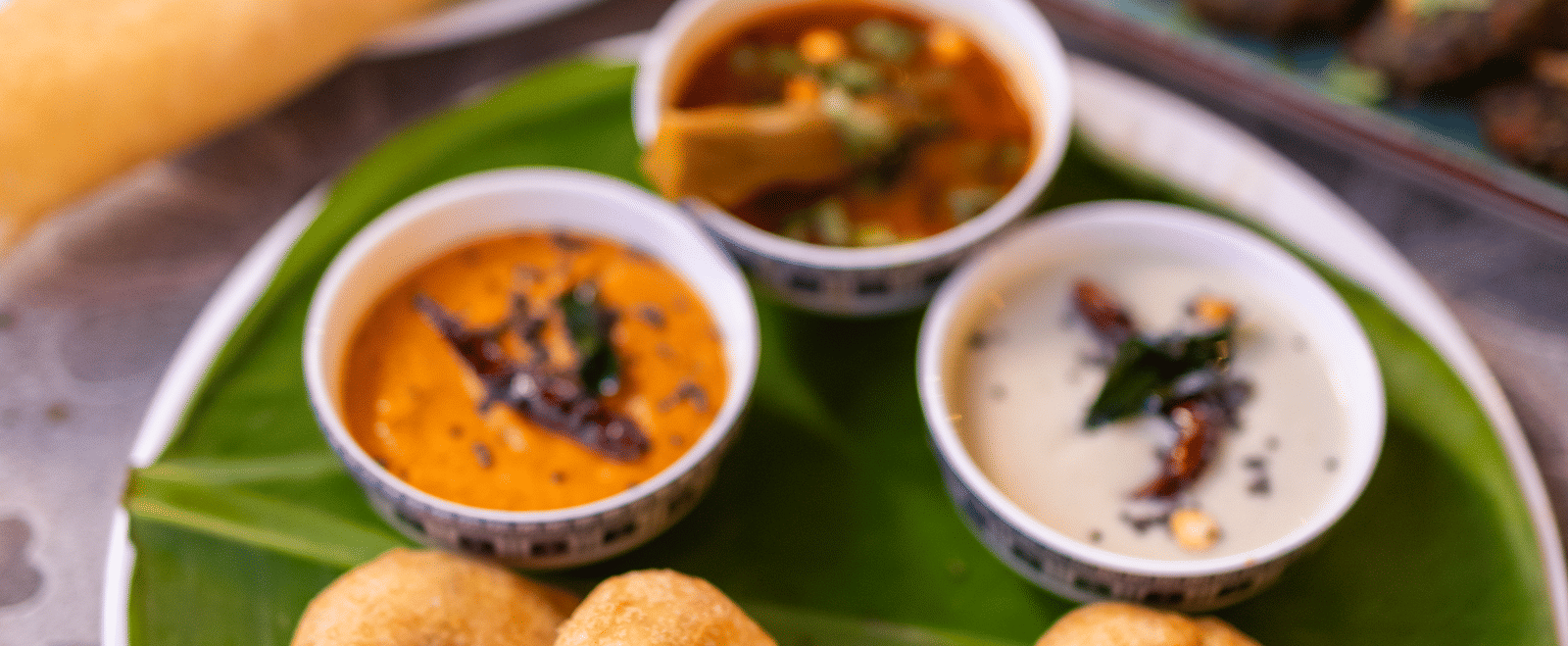 View of South Indian food, including idli or vada, on a banana leaf at Pravasa Stay Luv Kush, Indore.