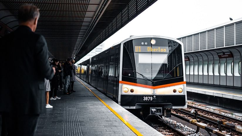 a train travelling to a train station with a person looking on