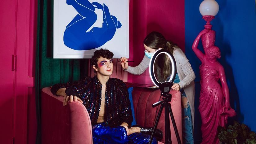 Image of a fashion blogger get ting his make up done in an event.