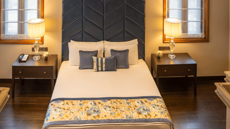 Presidential Suite bedroom with a bed set within an arched alcove at Kenilworth Hotel, Kolkata.