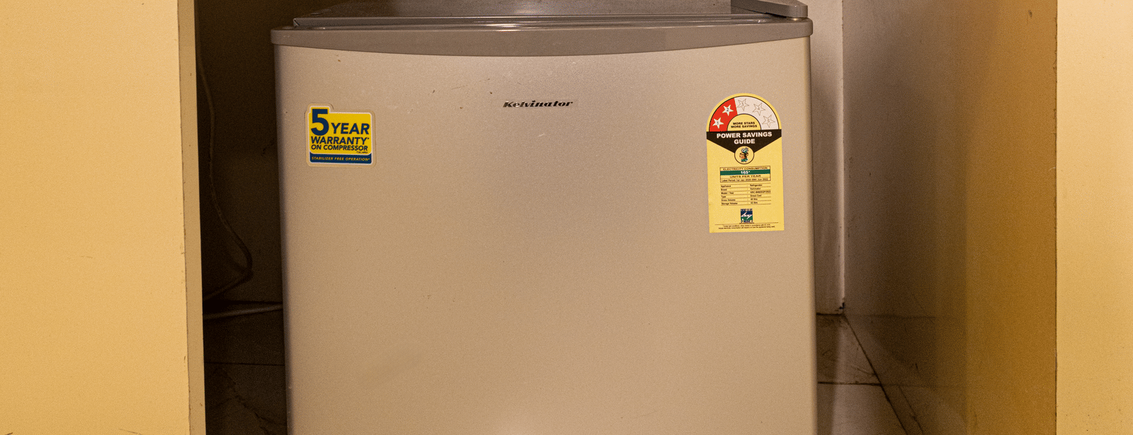 A mini refrigerator placed inside a built-in shelf at Hotel Seagull Digha.