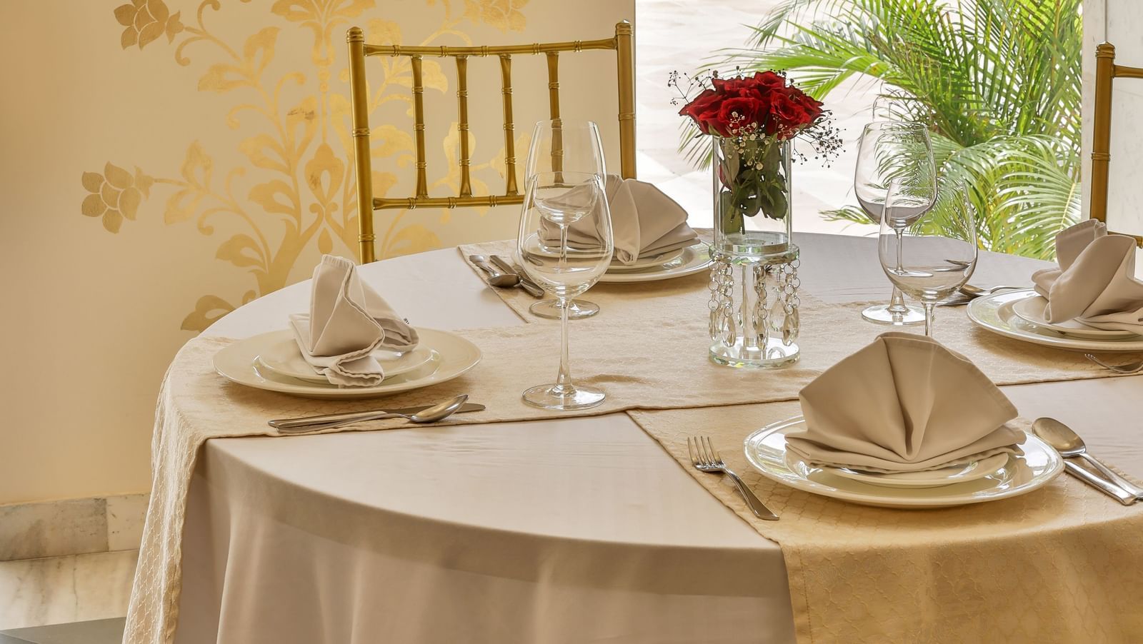 An indoor dining setup with a table and chairs next to a window at Royal Heritage Haveli.