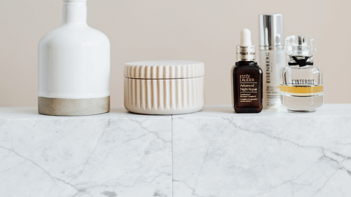 Skincare product containers of various shapes and sizes are placed side by side.