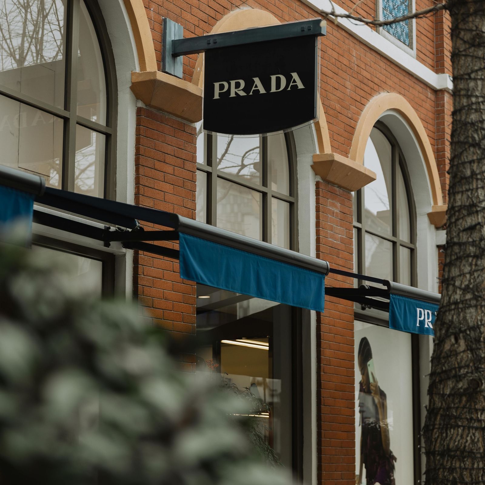 a close up shot of the Prada showroom flag hanging in the exterior of a building