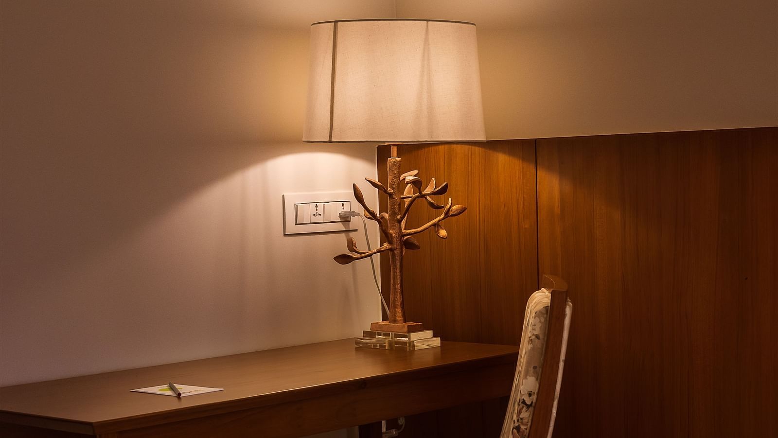 A study table in one of the rooms with a lamp next to it - Gamyam Retreat