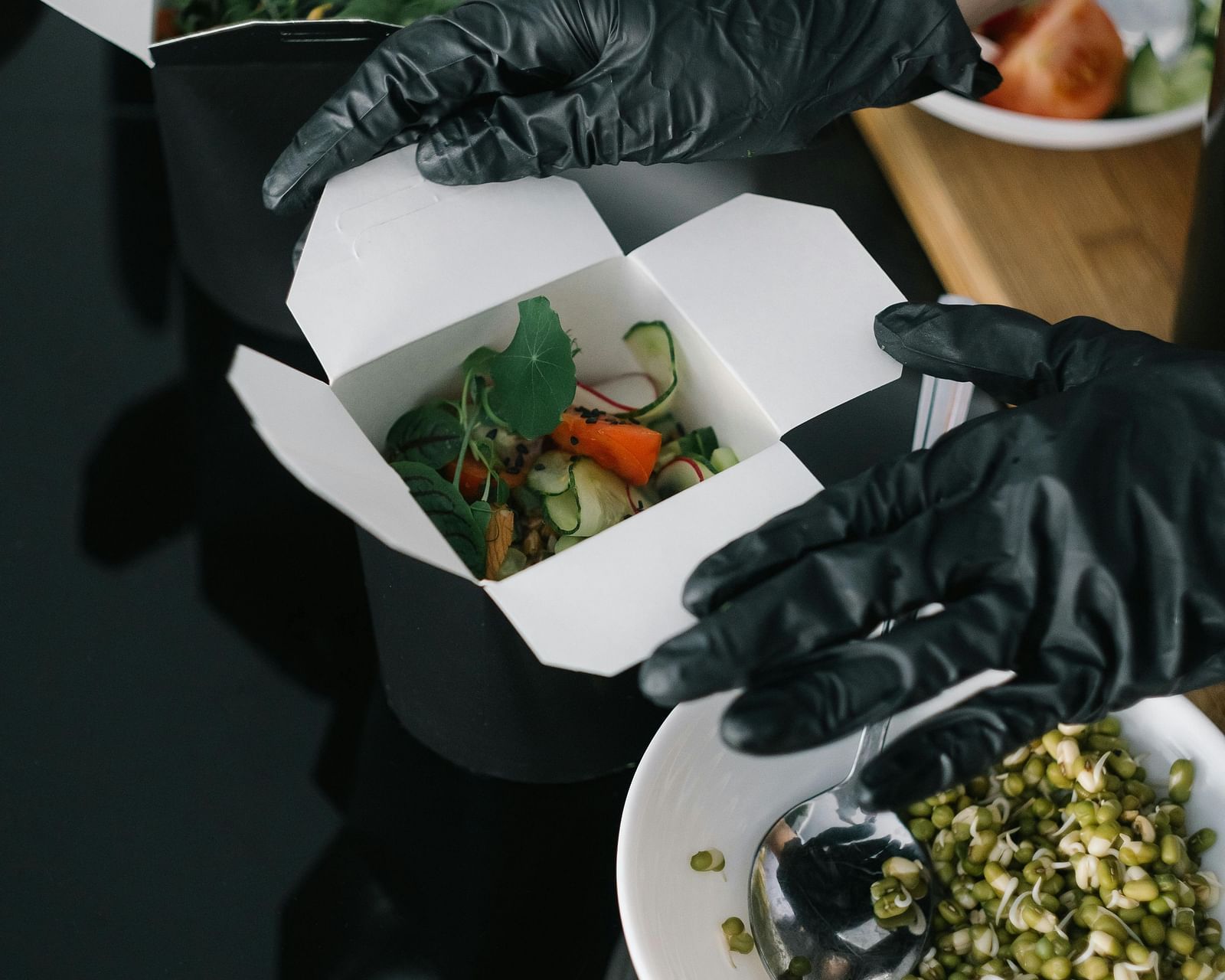An overhead view of a table with various foods getting packed, possibly in a restaurant setting.