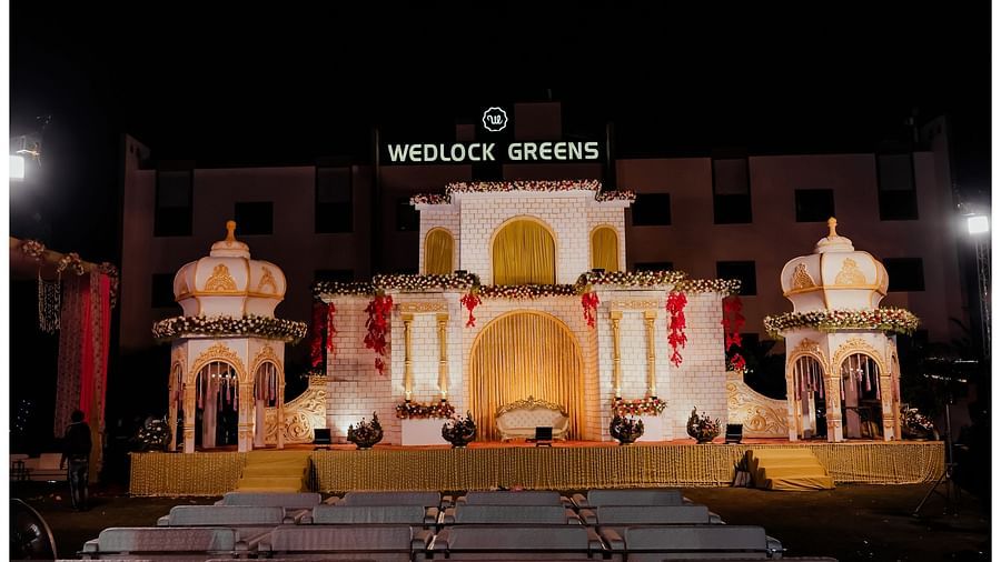 A decorated wedding podium, accompanied by elegant seats arranged in front of it. - Wedlock Greens Hotel Resorts Dhanbad
