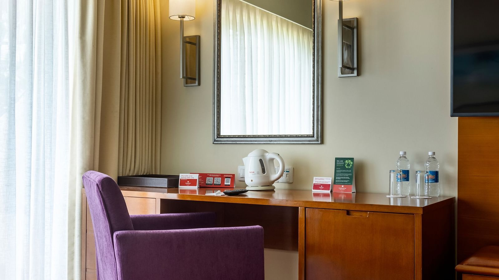 a sofa in front of table and a mirror on the wall inside Ocean front view - Caravela Beach Resort Goa
