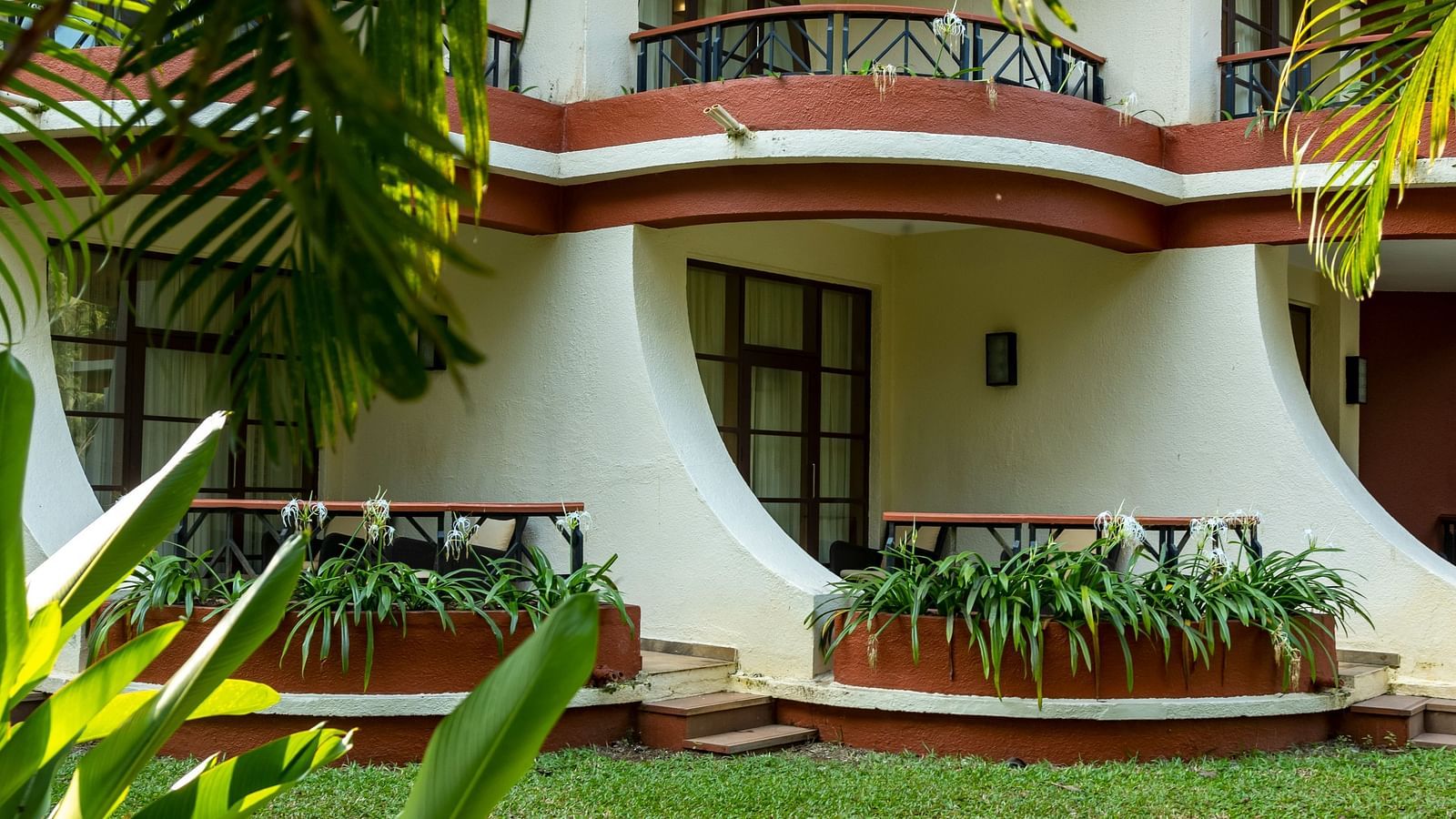 a view of the rooms from the garden with a manicured lawn in view - Caravela Beach Resort Goa