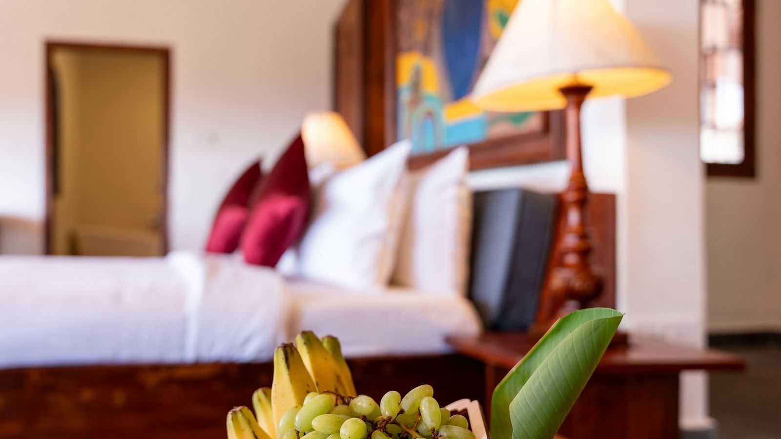 Close-up of a fruit basket on a table in a well-appointed hotel room with colorful decor. | Mango Hill, Yercaud