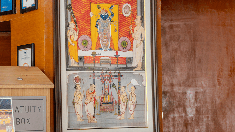 A hotel hallway featuring framed artwork, a wooden accent wall, and a small potted plan - Hotel Udai Median, Udaipur.