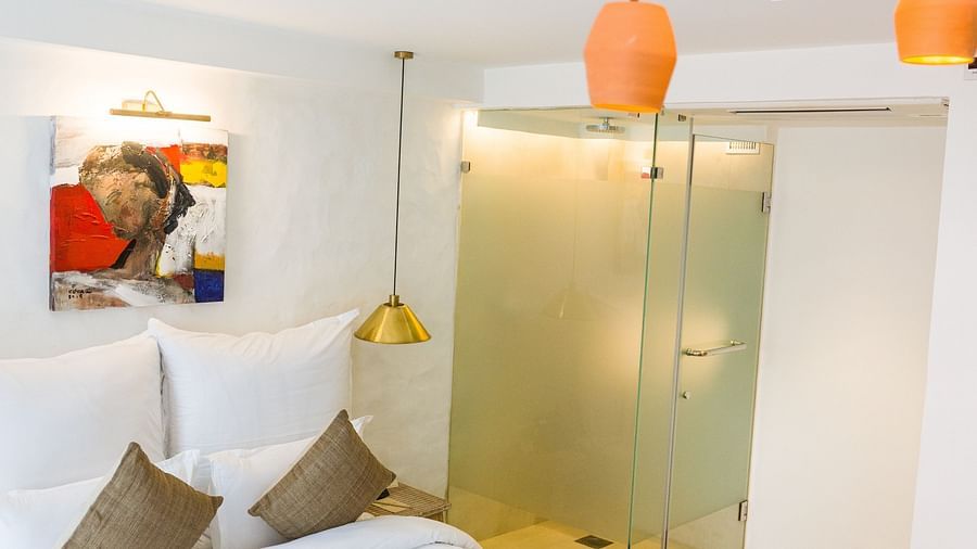 Deluxe loft room with a bed, bed side tables, and chandelier hanging - The Nanee