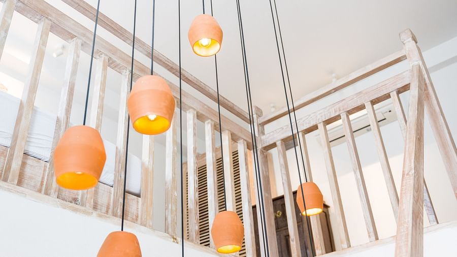 Deluxe loft room with chandelier hanging from the ceiling above the staircase leading to the loft - The Nanee