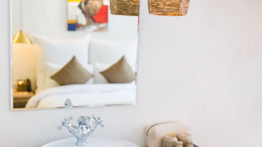 Deluxe loft room washroom area with a bamboo lamp hanging from the ceiling - The Nanee