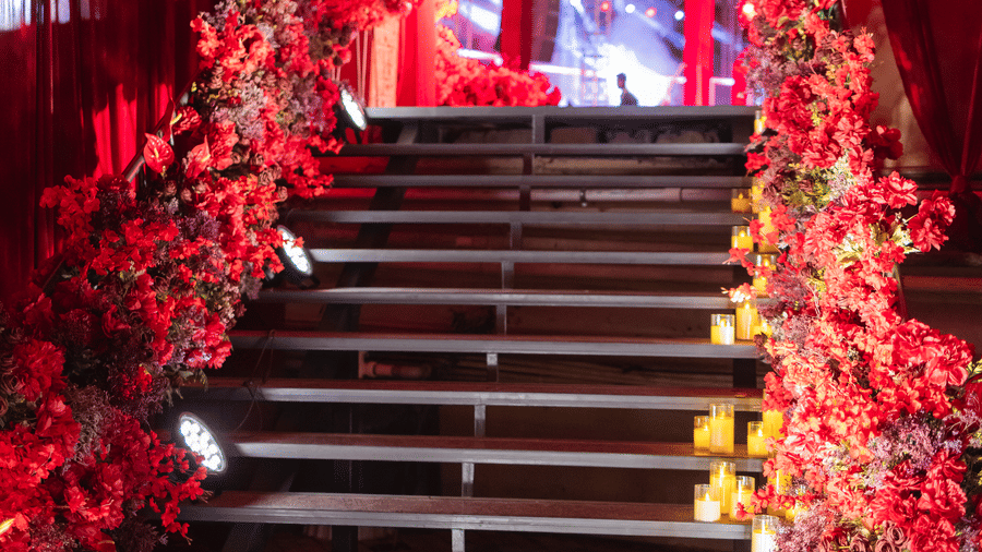 A staircase is decorated with red fabric and flowers | The Qualia Resort Club & Brewery, Udaipur