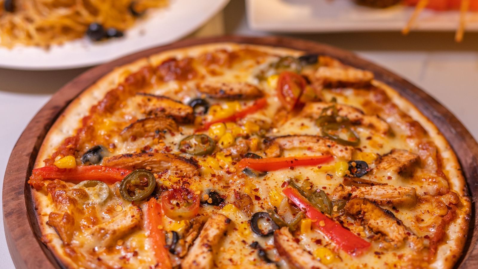 A delicious pizza served with various multi-cuisine delicacies - Darza Resorts.