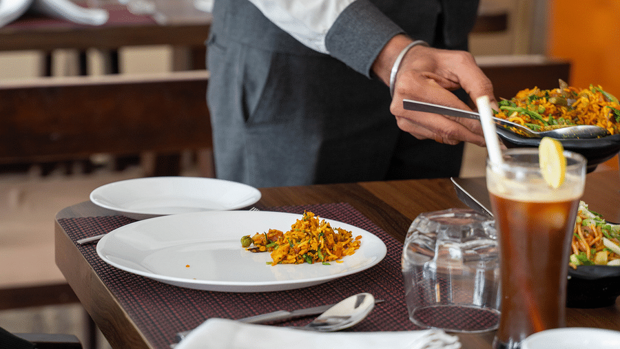  A waiter setting the dining table with attention to detail - Hotel Udai Median, Udaipur.