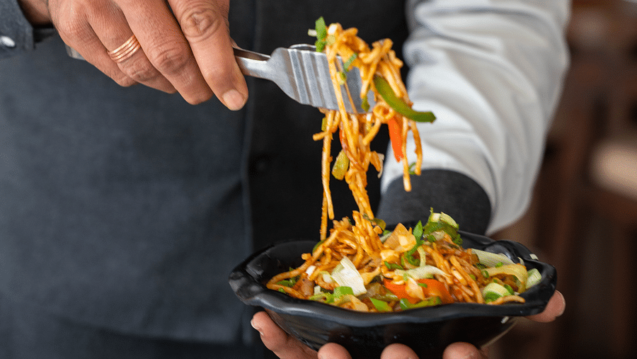 A waiter serving a dish - Hotel Udai Median, Udaipur.