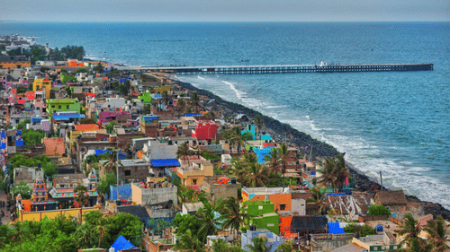 Aerial view of a coastal area with colourful buildings and a pier.