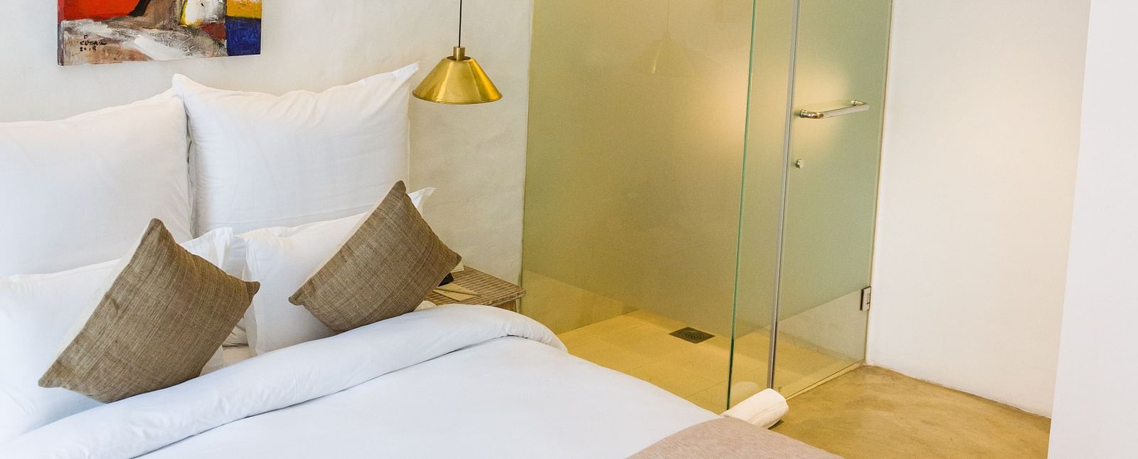 Deluxe loft room with a bed, bed side tables, and chandelier hanging - The Nanee