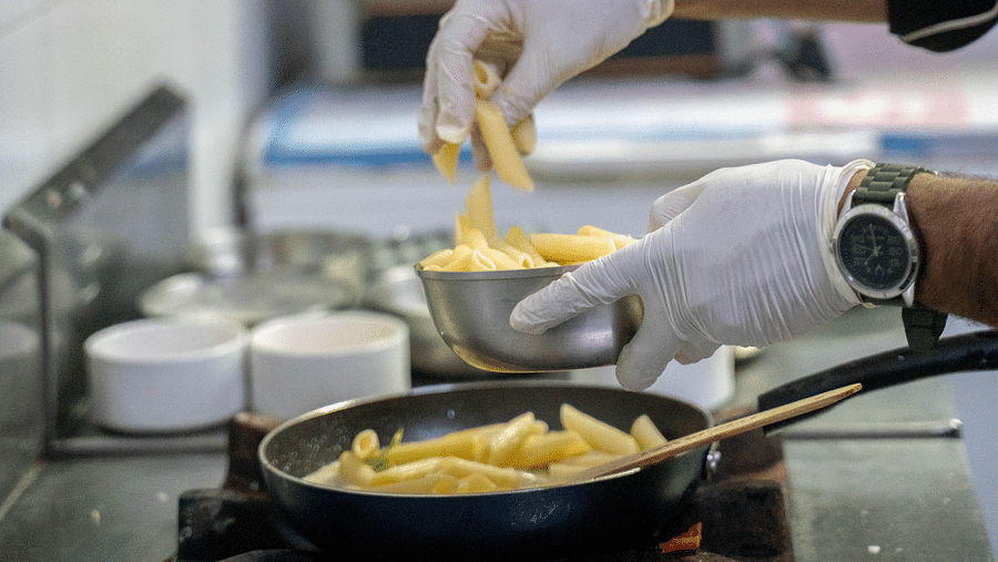 A chef preparing a dish in a professional hotel kitchen - Hotel Udai Median, Udaipur.
