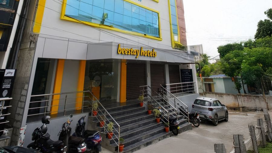 Side view of a multi-story building with blue-tinted windows and Beestays Hotels written on the facade - Beestay Hotels Financial District, Hyderabad 
