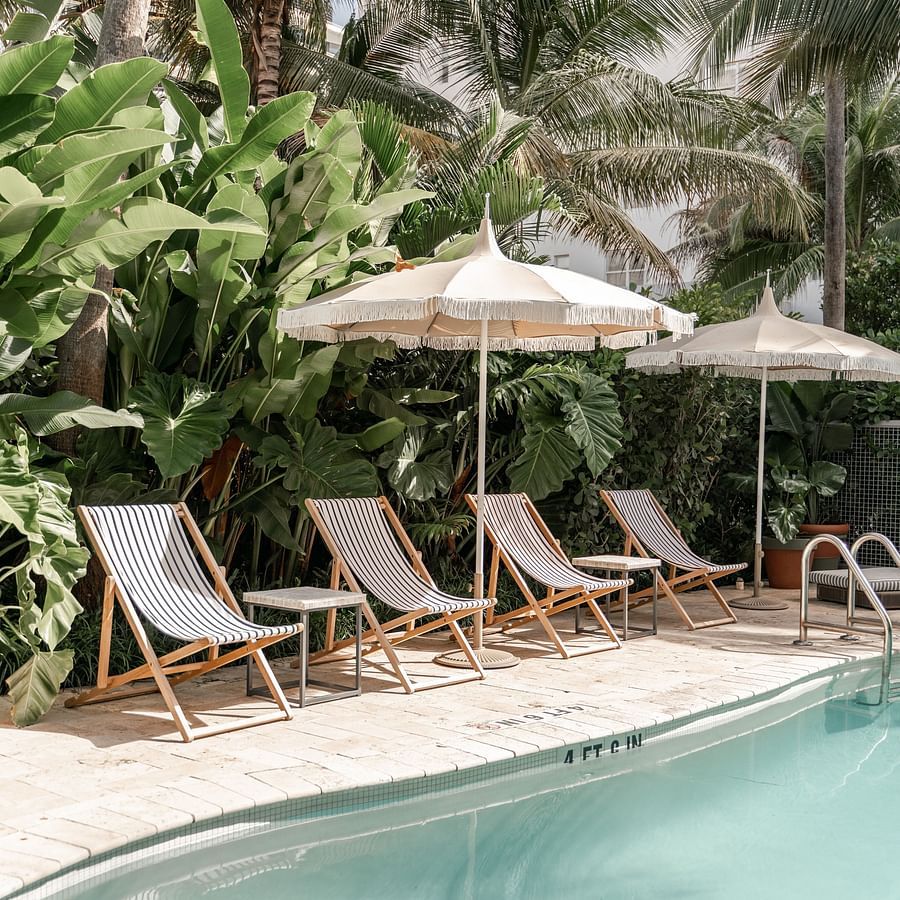 A view of the outdoor swimming pool with sun lounger on the deck
